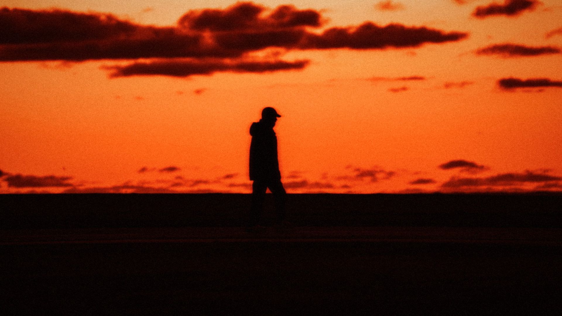 A figure walking along the horizon at sunset