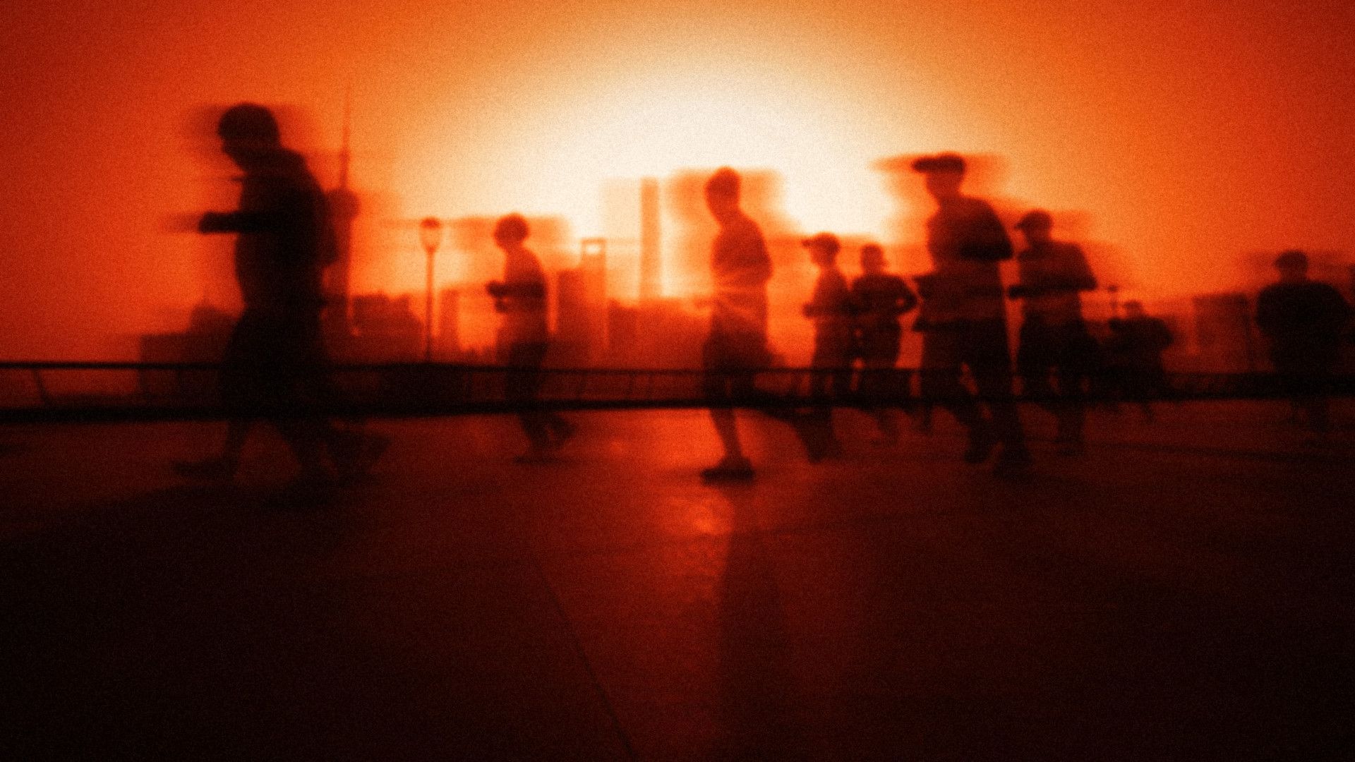 A team of runners moving together against a low sun